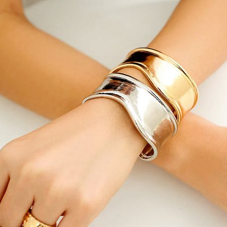 A stylish stack of wide, punk-inspired brass cuff bracelets.