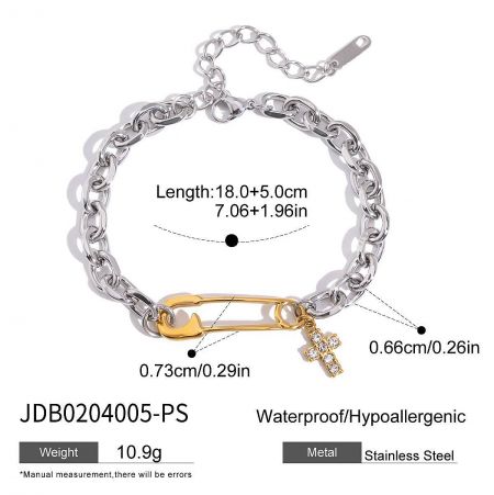 Flat lay view of the stainless steel bracelet, showing the full design with its gold safety pin and cross charm.