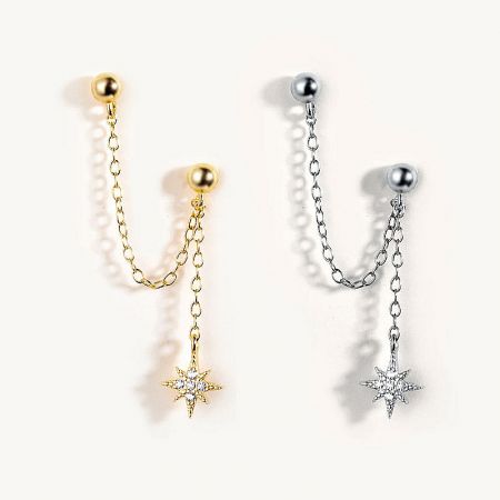 Detailed view of the star-shaped earrings in gold and silver, highlighting the embedded crystal accents.