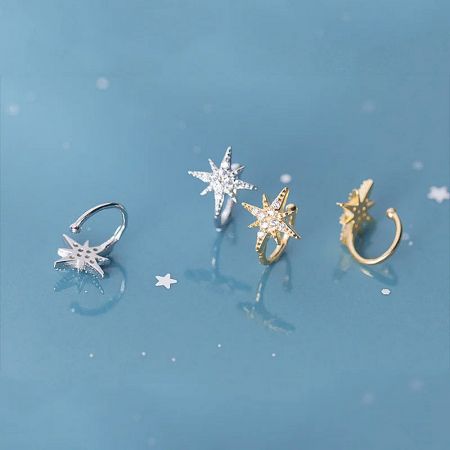 Orecchini a cuffia in zirconia a forma di stella in argento sterling 925 (Set di 5) - Un set di quattro orecchini a cuffia in argento sterling 925 a forma di stella con pietre di zirconia, esposti in finiture argento e oro su uno sfondo bianco.