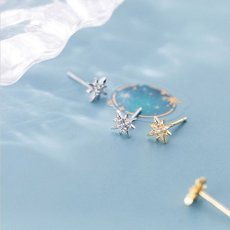 Both silver and gold star-shaped earrings with diamond-like centers.