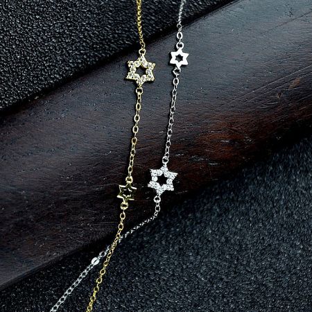 A pair of star-shaped pendant necklaces in both gold and silver finishes, showing the collection's versatility.