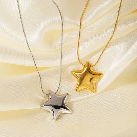 Close-up of the gold and silver star pendant necklaces on a satin background.