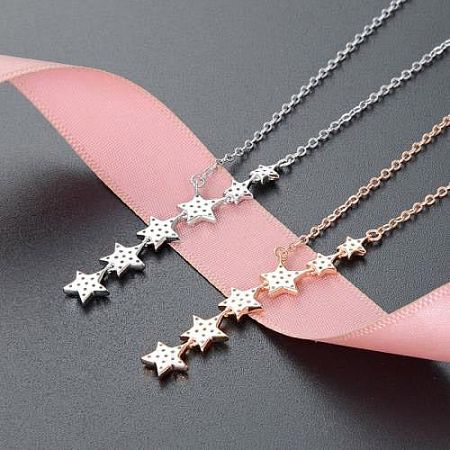 Three star pendant necklaces arranged to show the silver and rose gold options.