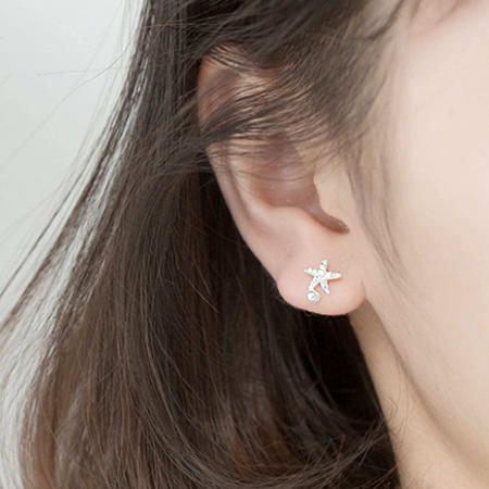 Model wearing the asymmetrical starfish pearl stud earring to show scale.
