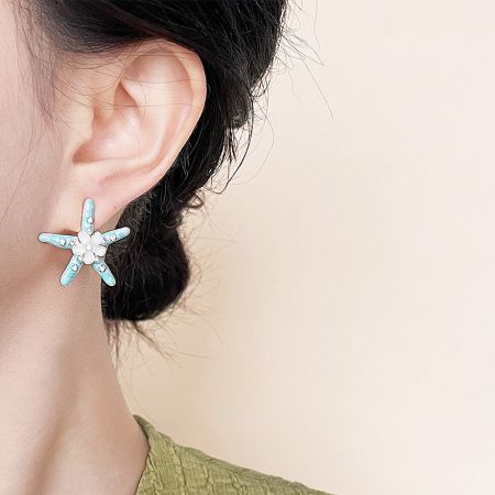 A model wearing the handmade enamel starfish stud earring to show its size and style.