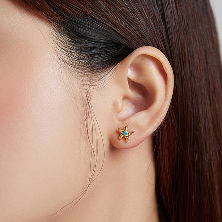 Close-up of the starfish turquoise earring on a model's ear, highlighting the intricate details.