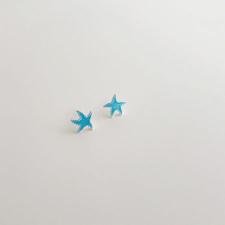 Another angle of the starfish earrings, showing the light blue enamel and silver plating.