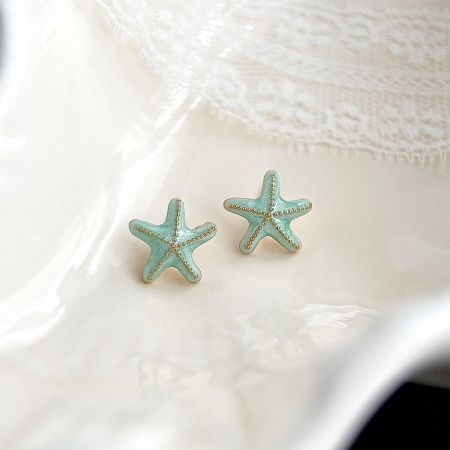 A pair of starfish earrings with a textured surface and gold detailing.