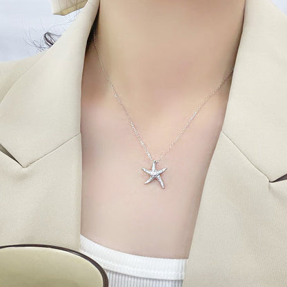Model wearing the elegant starfish necklace with a beige blazer, demonstrating its versatile style.