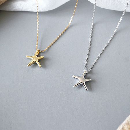 A clear product shot of both the gold and silver starfish necklaces.