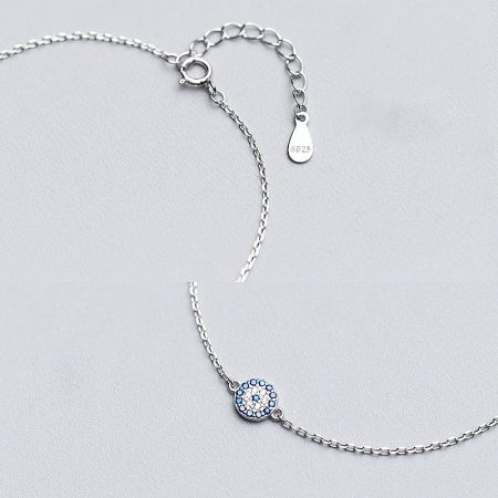 Detailed view of the S925 sterling silver evil eye charm with blue and white gemstones.