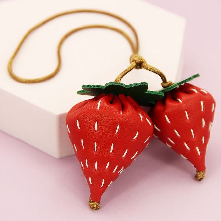 Close-up of the strawberry-themed pendant, highlighting the detailed texture and stitching.