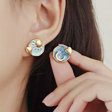 Close-up of the asymmetrical sun and moon stud earrings from the 5-pair set.
