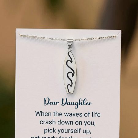 The surfboard pendant necklace presented as a thoughtful gift for a daughter.