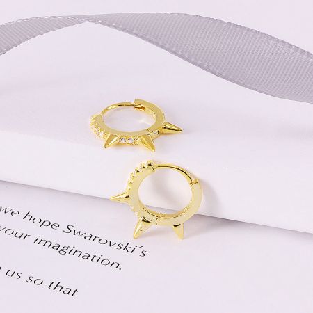 Close-up view of the gold punk-style hoop earring with crystal details.