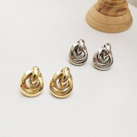 Multiple pairs of the swirl design earrings in both gold and silver finishes.