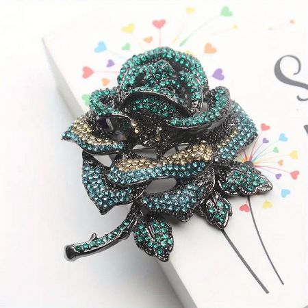 Close-up of the blue variant of the rose brooch, showcasing its sophisticated color and shimmering rhinestones.