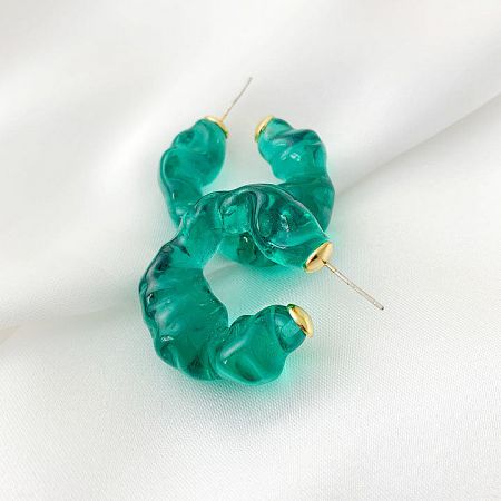 A pair of teal green resin earrings with a unique wavy design.