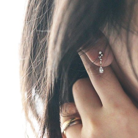 Close-up detail of the micro-inlaid zircon and teardrop crystal on the 925 silver earring.