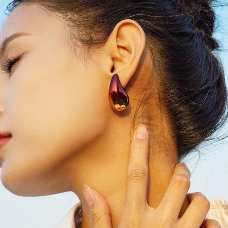 Close-up of a woman wearing a stylish stainless steel gradient teardrop earring.