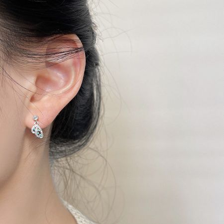 Detailed view of the teardrop-shaped dangle earring adorned with clear zircon gemstones.