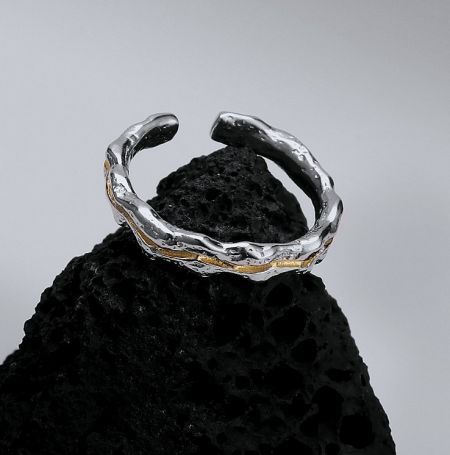 925 Sterling Silver Double Plating Ring - A close-up of the 925 Sterling Silver Double Plating Ring, showcasing its unique textured finish with elegant gold accents, resting on a dark, natural surface.