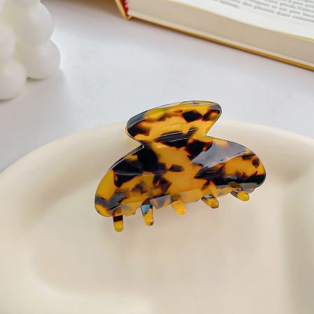 Classic brown tortoiseshell acetate hair clip on a neutral background.