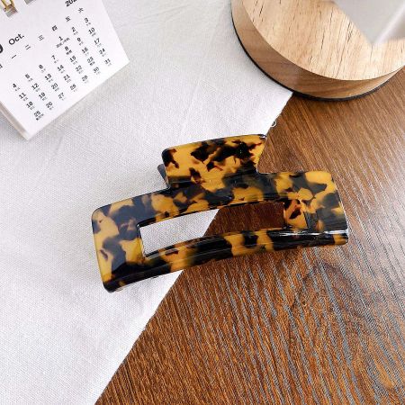 A close-up of a classic tortoiseshell square acetate hair clip.