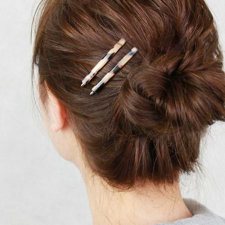 A model showcasing how the stylish tortoiseshell bobby pins secure a neat hair bun.