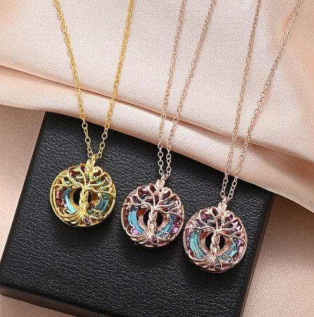 Three variations of the Tree of Life necklace in gold, silver, and rose gold finishes.