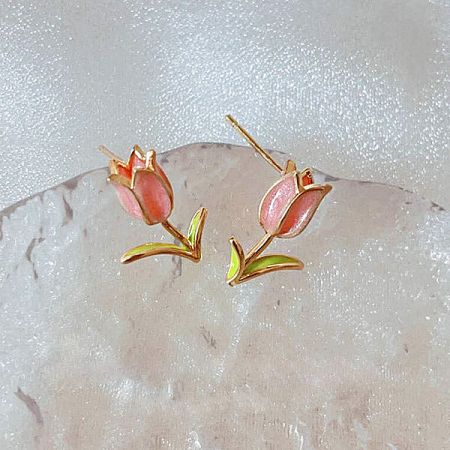 A pair of gold-plated tulip earrings with vibrant pink petals and green leaves.