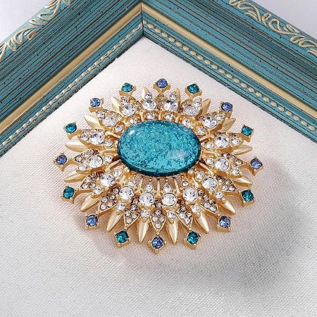 Full view of the gold-toned sunburst brooch with a vibrant turquoise center stone, perfect for a bohemian look.