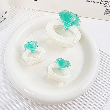 A collection of diamond ring-shaped hair clips scattered on a surface, showcasing their design.