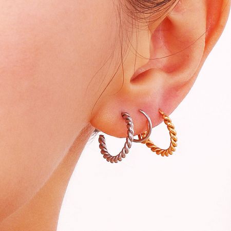 Three variations of the spiral twist earrings shown in silver, rose gold, and gold finishes.