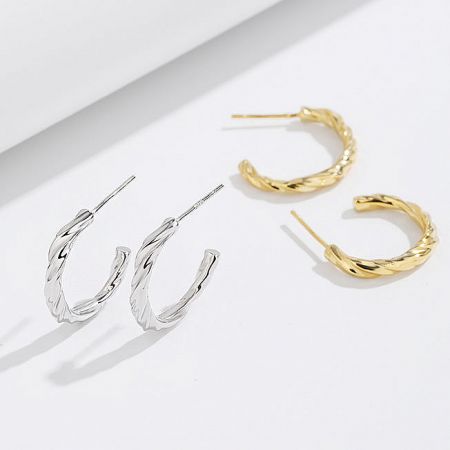 Close-up view of the intricate twisted knot design on the sterling silver C-shape earrings.