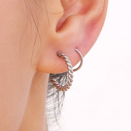 Detailed close-up of a single silver spiral twist earring, highlighting the intricate rope-like texture.