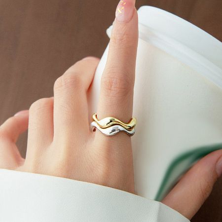 Close-up of a two-toned 925 sterling silver wavy ring, showcasing both gold and silver finishes.