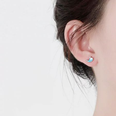 Model wearing the cute blue whale stud earring to show its size and appearance on the ear.