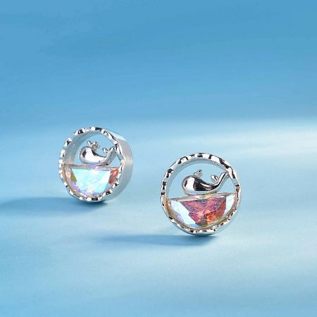 A pair of sterling silver whale earrings shown from a different angle to display the iridescent quality of the opal gemstones.