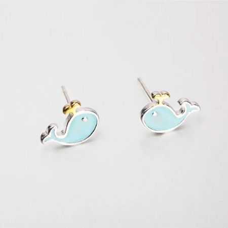 Angled shot of the whale earrings highlighting the silver posts and intricate design.