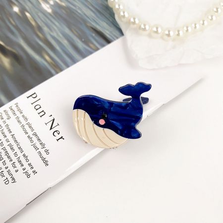 Detailed view of the blue whale-shaped acetate hair clip.