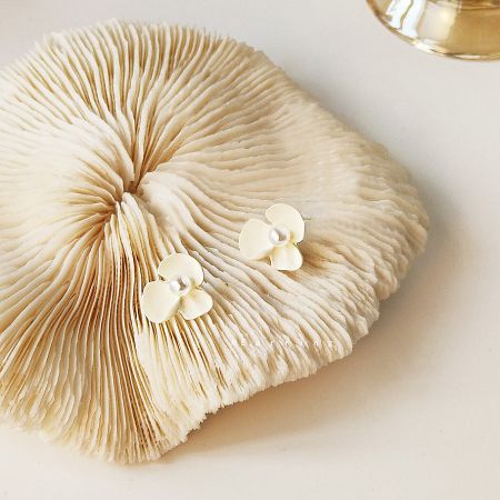 A creative display of the white flower earrings on a decorative mushroom.