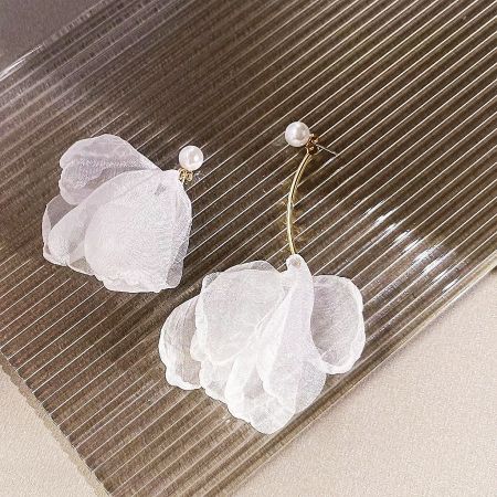 A pair of white flower earrings with elegant gold stems and pearl centers, displayed on a neutral background.