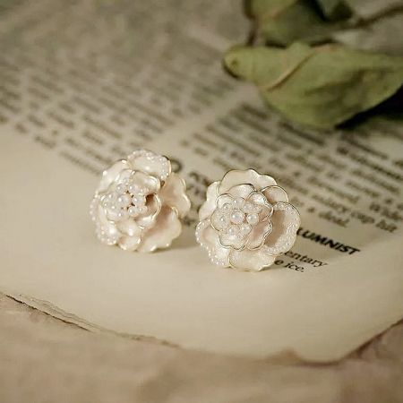A pair of white camellia flower earrings with delicate pearl accents.