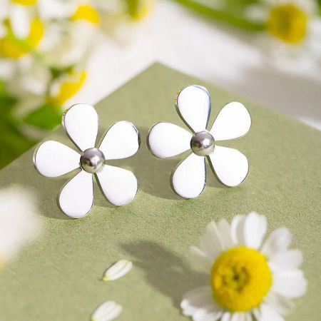 The white enamel version of the daisy flower earrings with a silver center, showcasing design versatility.