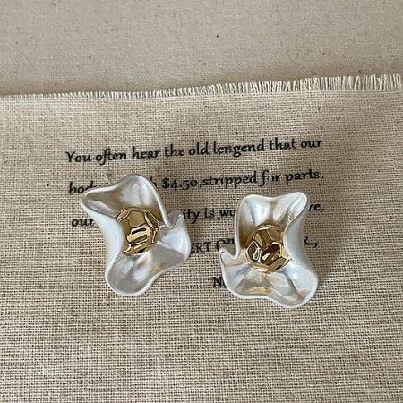 Elegant white petal flower stud earrings with polished gold centers, showcasing vintage-inspired brass jewelry design.