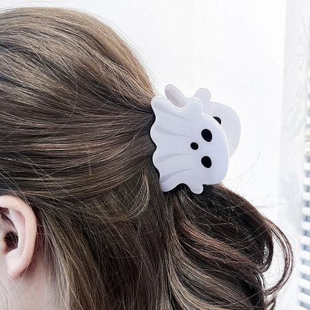 A close-up of the white ghost hair clip being worn in brown hair, showing its cute and spooky design.