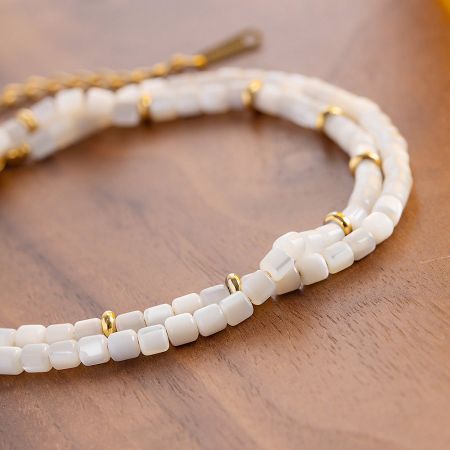 The versatile design of the white and gold beaded jewelry piece.