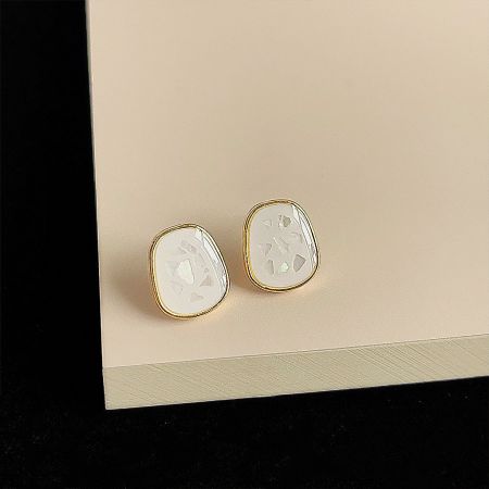 A pair of white enamel earrings with a polished 14k gold plated rim.